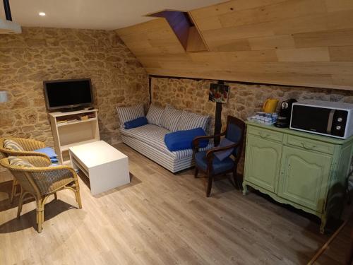 un salon avec un canapé et une télévision dans l'établissement La Terrasse Bleue, havre de paix avec vue sur le Célé, à 15 min de Figeac, à Corn