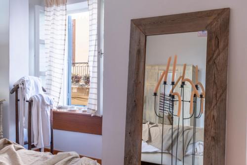 a mirror with a wooden frame in a bedroom at Amymone and Adiandi in Nafplio