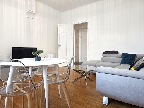 un salon avec une table et un canapé dans l'établissement Le Bout du Pont - 5 min à pied de la gare Villebourbon et de l'hypercentre - Vue sur Pont Vieux - Grande terrasse - 8 couchages - 3 chambres spacieuses - 4 lits - Places de stationnement gratuites au pied de l'immeuble, à Montauban