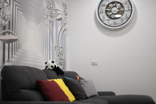a panda bear sitting on top of a couch with a clock at Giorgina'S Suite in Montecorvino Pugliano