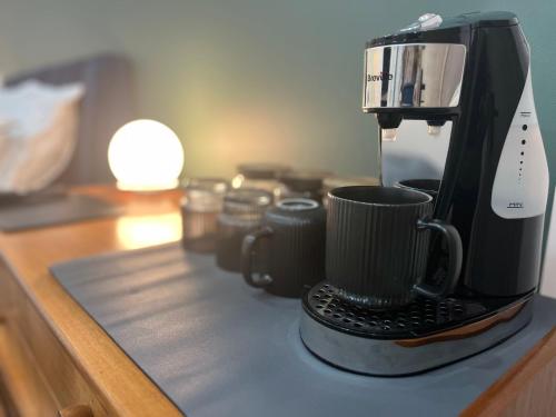 a coffee maker with a cup on a counter at Luxury Room in the New Forest in Eling