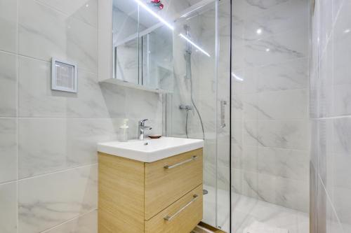 une salle de bain avec un lavabo et une douche dans l'établissement Center of Paris l Fully equipped and Cozy, à Paris