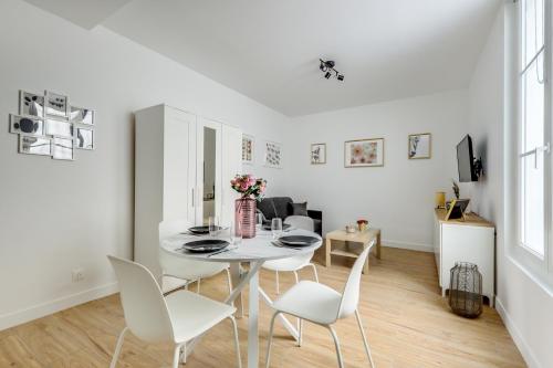 une salle à manger blanche avec une table et des chaises blanches dans l'établissement Center of Paris l Fully equipped and Cozy, à Paris