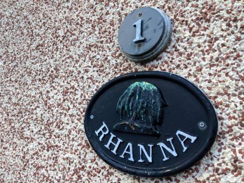 a black sign with a picture of a helmet at Rhanna, Mallaig in Mallaig