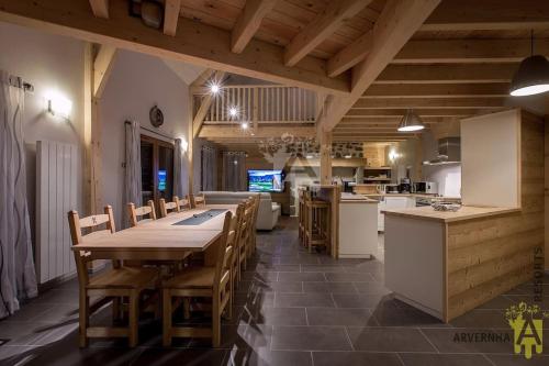 une grande cuisine avec une grande table et des chaises dans l'établissement Gîte du Père François, à Chambon-sur-Lac