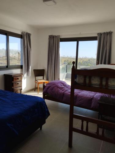 a bedroom with two beds and a large window at Casal Sur in Potrero de Garay
