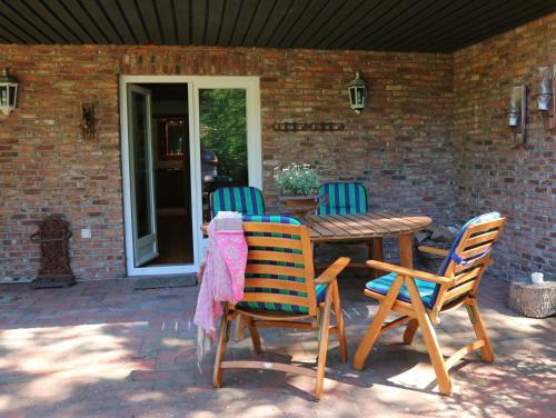 a wooden table and chairs on a patio at Gänsehaus in Karolinenkoog