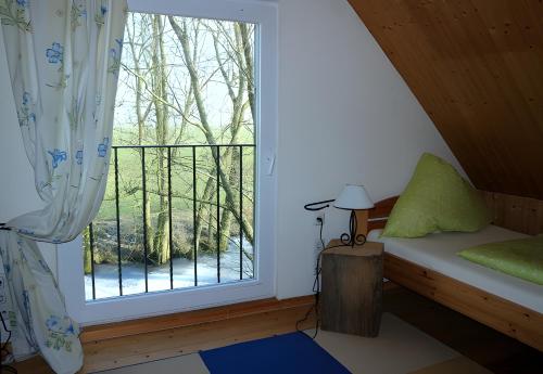 a room with a window with a bed and a balcony at Gänsehaus in Karolinenkoog