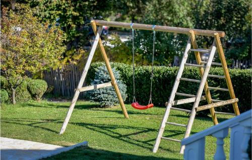 a swing set in a yard with a ladder at Amazing Home With Swiming Pool in Gačice