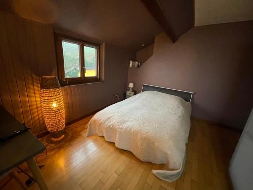 a bedroom with a white bed and a window at Gîte marguerite in Sainte-Marie-aux-Mines