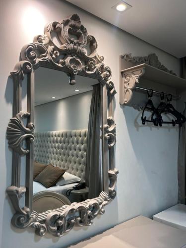 a mirror on a wall in a bedroom at Maximus Sottile Hotel in Ji-Paraná
