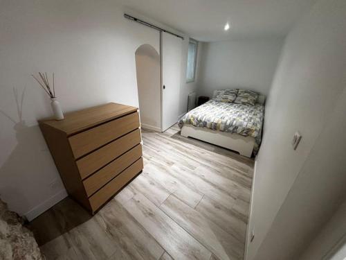 une chambre avec un lit et une commode en bois dans l'établissement Superbe appartement Roquevaire, à Roquevaire