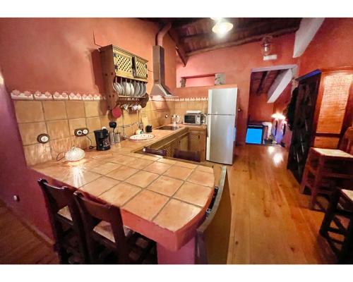 a kitchen with a wooden table and a refrigerator at Casa Alfurán in Alfornón