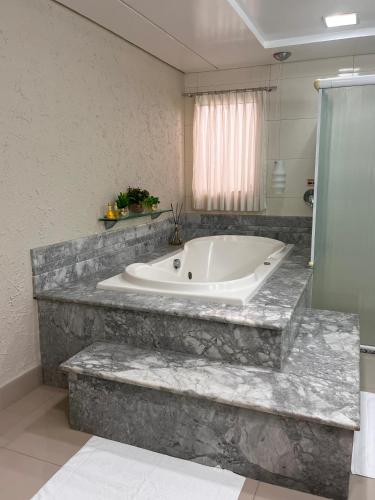 a bathroom with a large tub in a room at Maximus Sottile Hotel in Ji-Paraná