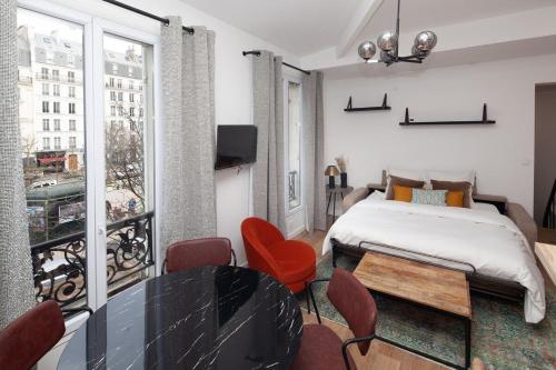 une chambre avec un lit, une table et des chaises dans l'établissement Paris 15 - Tour Montparnasse - Bd Pasteur - 2 pièces, à Paris