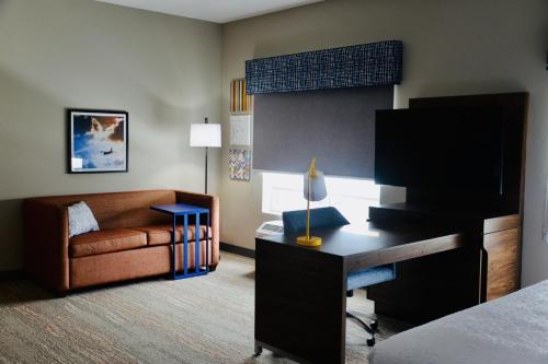 a hotel room with a bed and a desk and a couch at Hampton Inn Cabot in Cabot