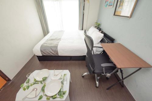 a small room with a bed and a desk with a chair at 渋谷駅徒歩6分!高速インターネット光回線 in Tokyo
