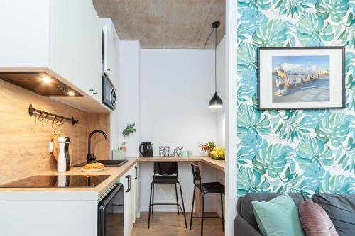 a small kitchen with a sink and a table at Apartamenty Silver Place in Szczecin