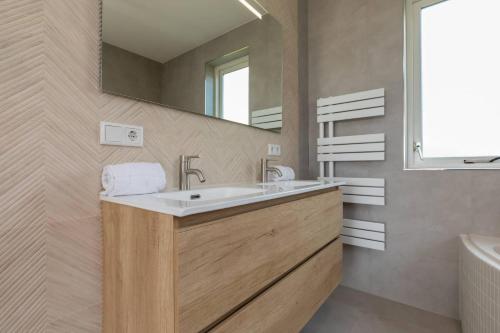 a bathroom with a sink and a mirror at Hello Zeeland - Appartement Kusthuys 2 - 2025 in Zoutelande