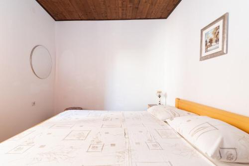 a bedroom with a large bed with white sheets at Apartments Din in Kukljica