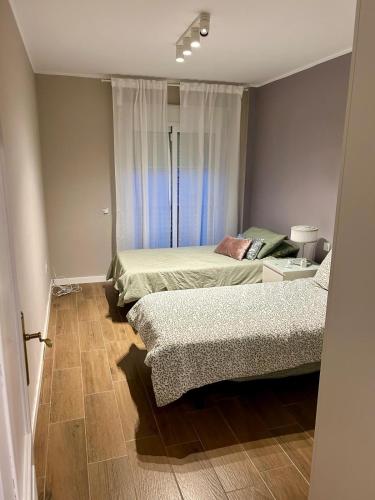a bedroom with two beds and a window at Calm House in Arona