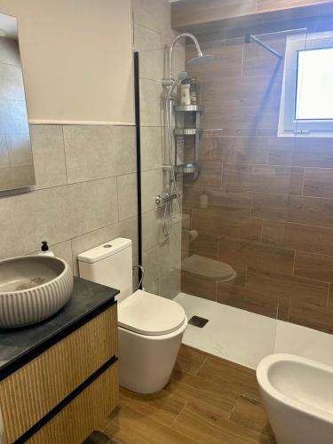 a bathroom with a toilet and a sink and a shower at Calm House in Arona