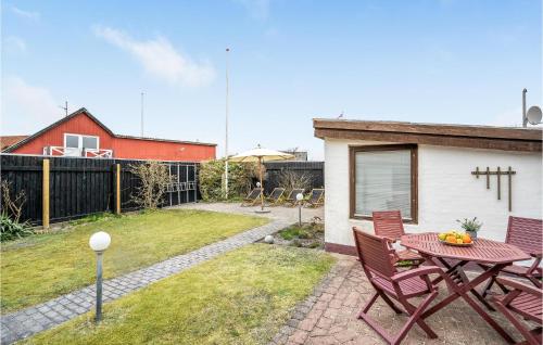 a patio with a table and chairs in a yard at 2 Bedroom Beautiful Home In Løkken in Løkken