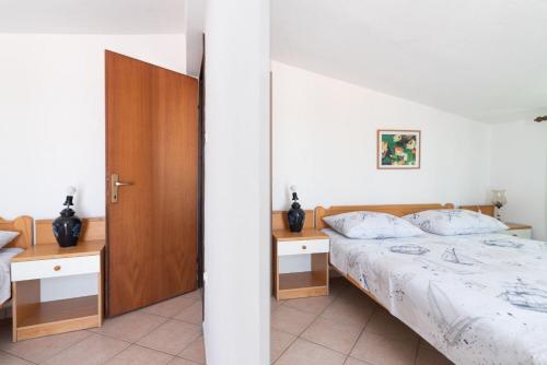 a bedroom with a bed and two night stands at Apartments Din in Kukljica