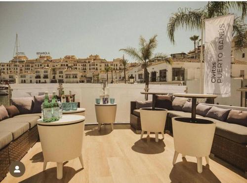 a living room with couches and tables on a balcony at Sail & Stay in Castillo de Sabinillas