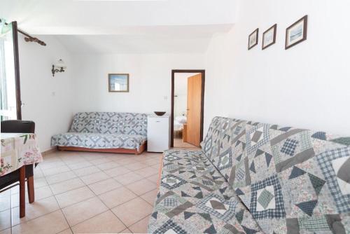a living room with a couch and a table at Apartments Din in Kukljica