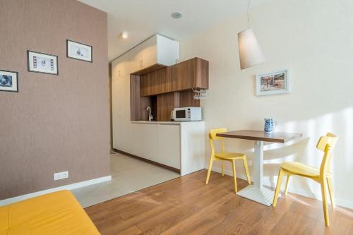 New Gudauri Studio near main Gondola lifts في غودواري: مطبخ مع طاولة وكراسي في الغرفة