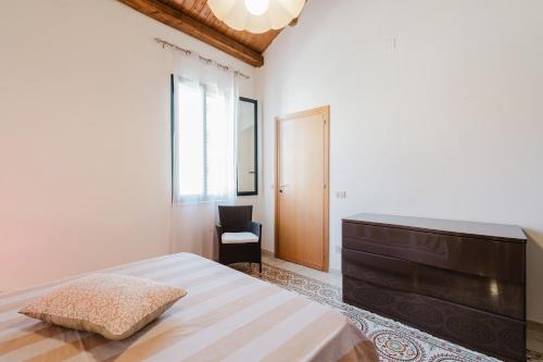 a bedroom with a bed and a dresser and a chair at Da Giovanni A Custonaci in Custonaci