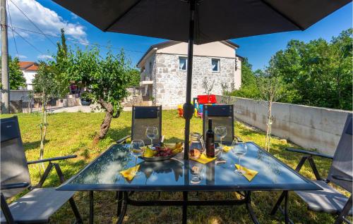 a table with a bowl of fruit and an umbrella at Lovely Home In Rasopasno With Wifi in Rasopasno