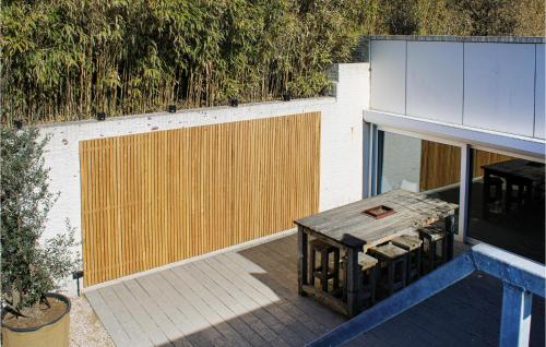 a patio with a wooden table and a fence at Thalatta in Noordwijk