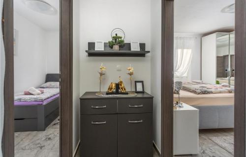 a bedroom with two beds and a dresser and a mirror at Lovely Home In Rasopasno With Wifi in Rasopasno
