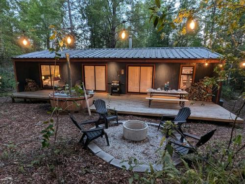 uma cabana na floresta com cadeiras e uma mesa em Casa del bosque em Catrico