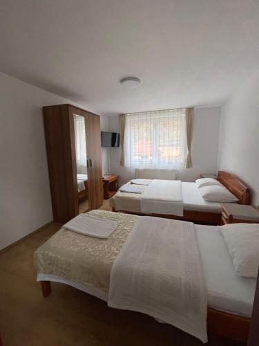 a bedroom with two beds and a window at Pensiunea Vătafu in Gura Râului
