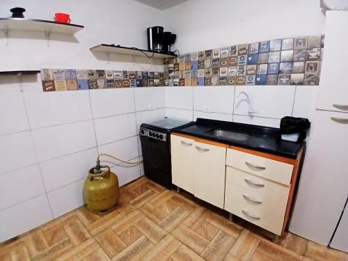 a small kitchen with a sink and a stove at Casa Próx.Aeroporto/10minutos do centro Curitiba in Curitiba