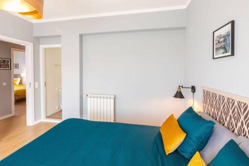 a bedroom with a blue bed and yellow pillows at Modern apartment 5 mins walking to the Santuary in Fátima