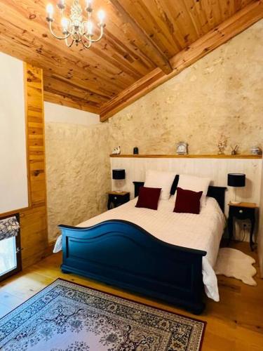 une chambre avec un grand lit dans une pièce dans l'établissement Gite La Vieille Grange, with pool in the Dordogne, à Saint-Privat-des-Prés