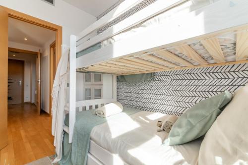 a bedroom with a bunk bed with white walls at Penthouse with Private Terrace & Pool Access in Cornellà de Llobregat
