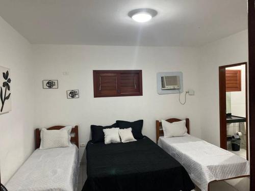 ein Zimmer mit zwei Betten und einem Fenster in der Unterkunft Casa pé na areia na praia de Antunes em Maragogi in Maragogi