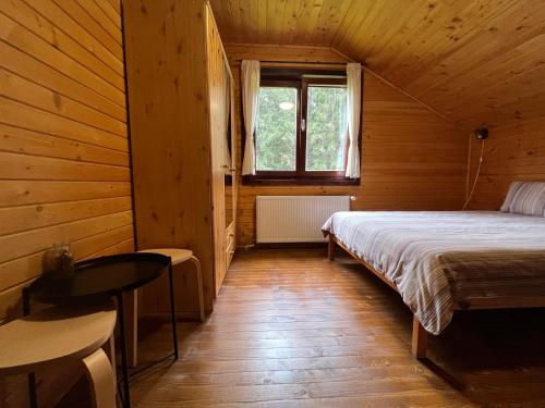 a bedroom with a bed in a wooden cabin at Casa de Vacanta Dintre Brazi in Topliţa