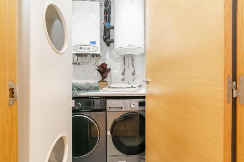 a small kitchen with a washer and dryer at Penthouse with Private Terrace & Pool Access in Cornellà de Llobregat