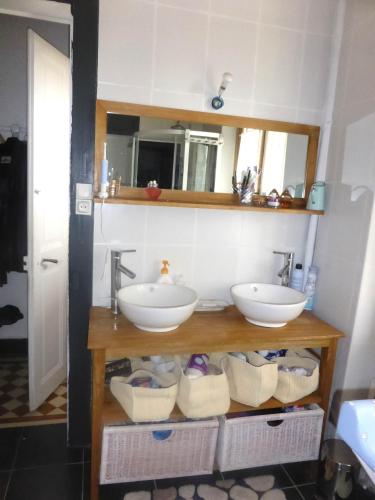 une salle de bains avec deux lavabos sur une étagère avec des paniers dans l'établissement Chalet station jusqu'à 13 personnes 5 nuits minimum ou 7 en période de vacances scolaires, à Samoëns