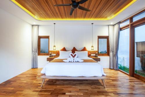 a bedroom with a bed with a ceiling fan at Seminyak Villa Paya paya Luxury near beach-Potato Head in Seminyak