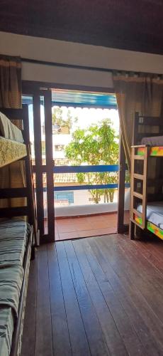 a room with a view of a balcony with beds at Ganesha Hostel in Pipa