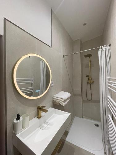 une salle de bain blanche avec un lavabo et un miroir dans l'établissement Eden de Thau 1ère ligne, à Bouzigues