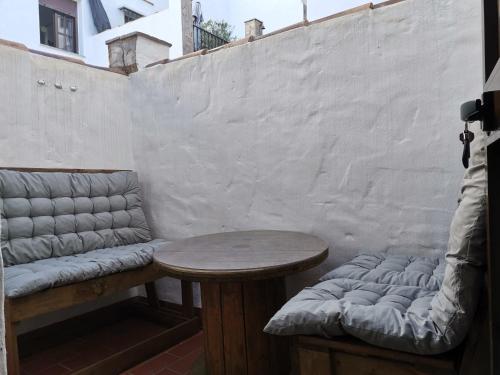 a table and a bench sitting next to a wall at Casa rural Isabel, en Sierra de Grazalema in Benaocaz