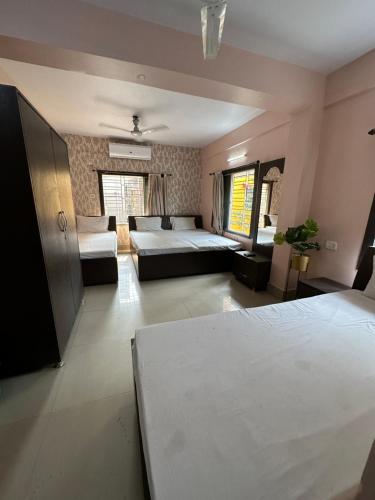 a large room with two beds and a couch at Jagannath Residency And Prasadam in Kolkata